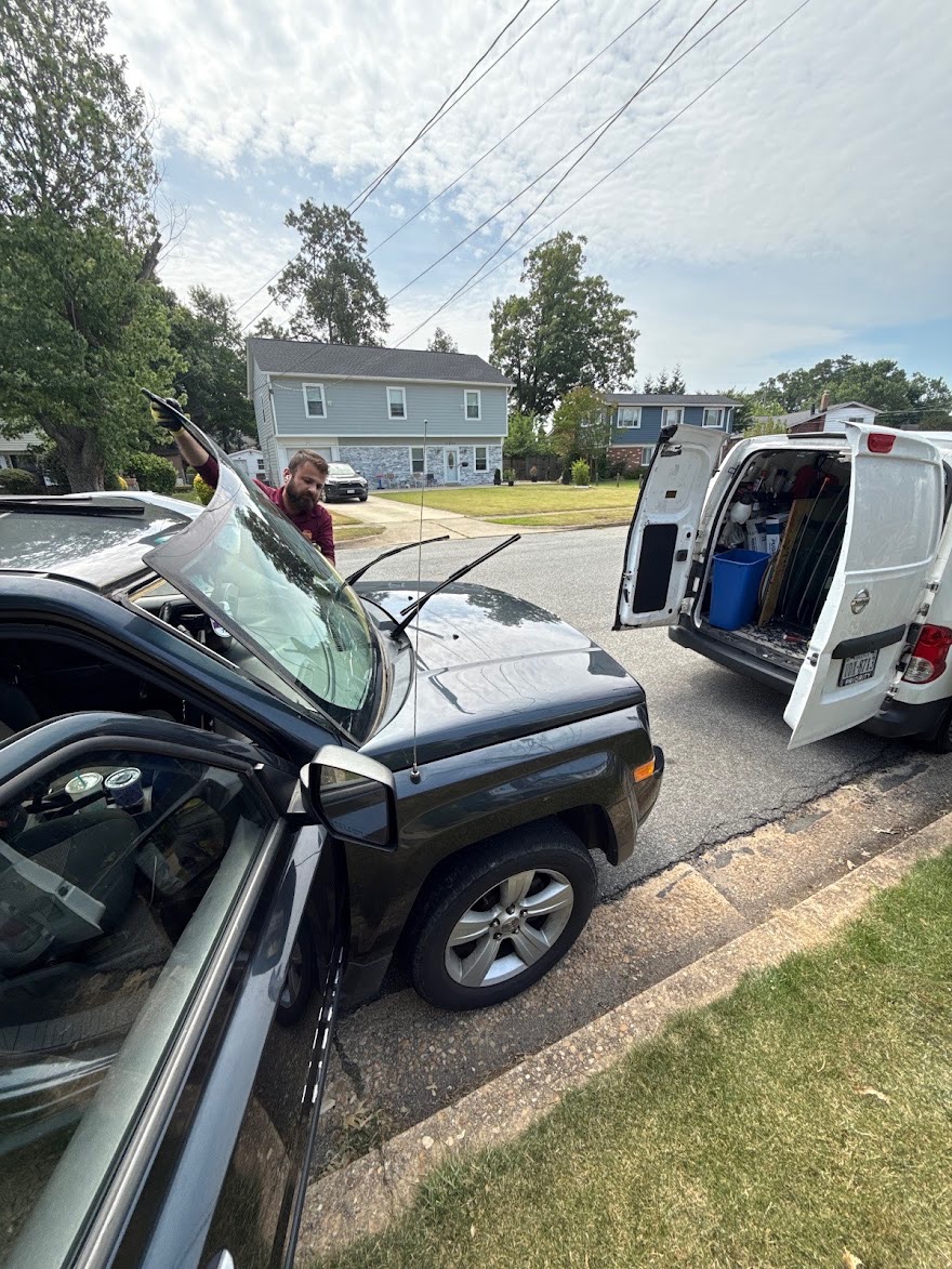 Mobile service van parked beside a truck during a windshield swap