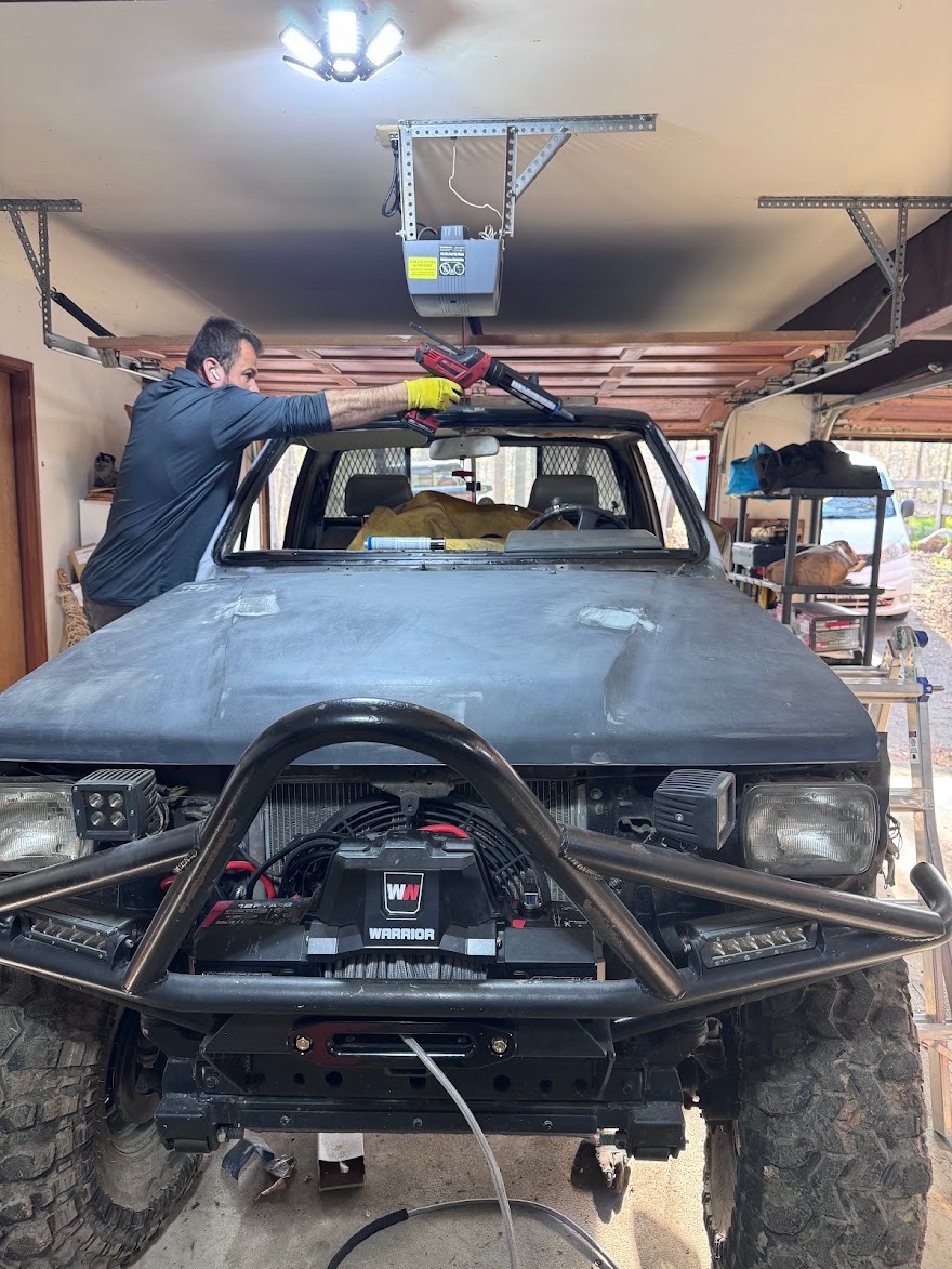 Windshield work on a lifted off-road truck in a garage